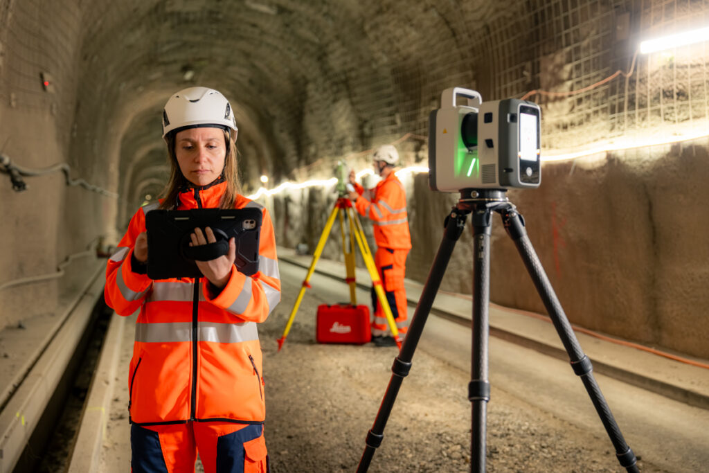 A worker uses a Leica geosystems scanner in a tunnel.
